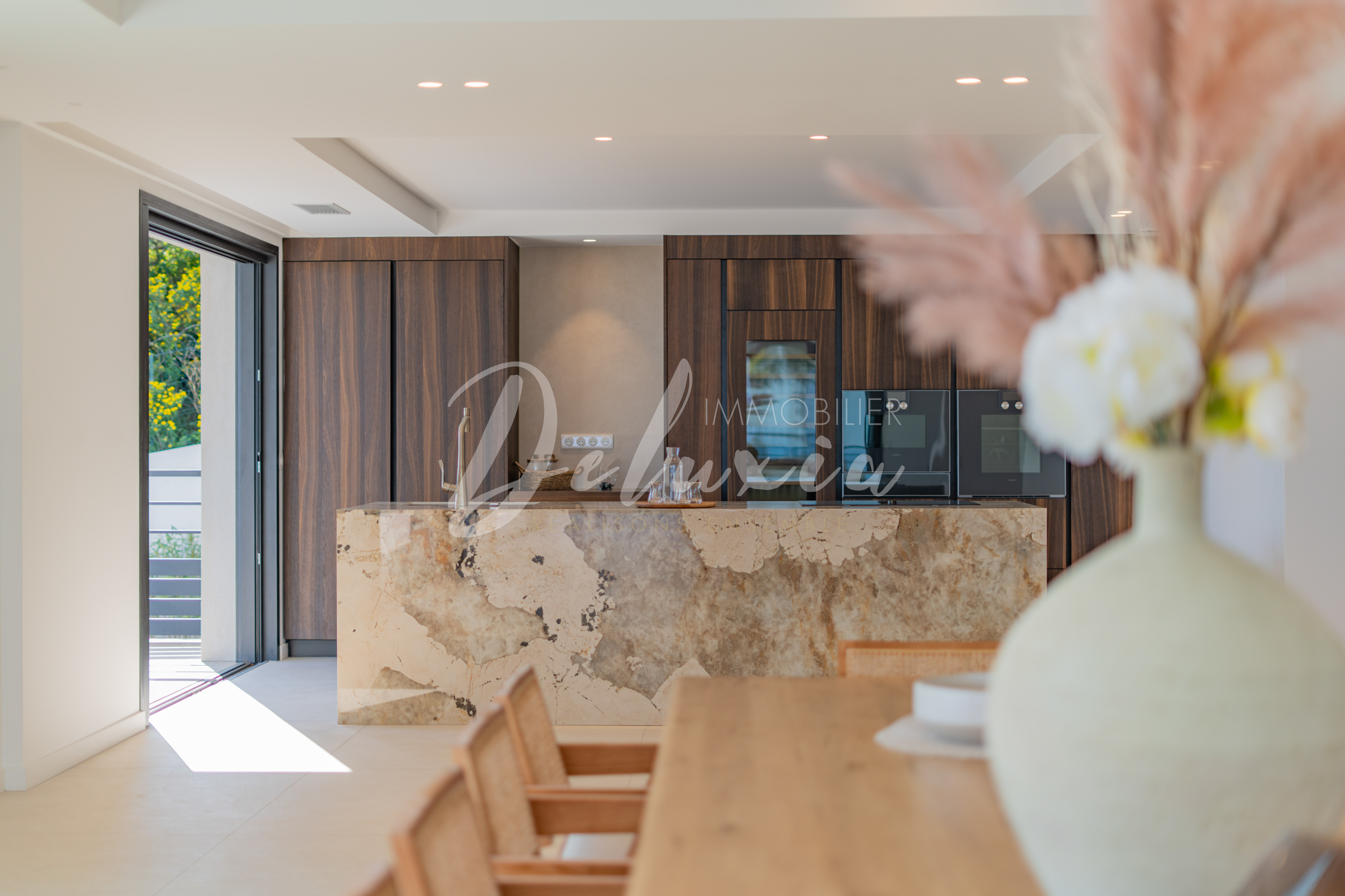 Villa à vendre aux Issambres avec cuisine équipée design, îlot central et matériaux de qualité.