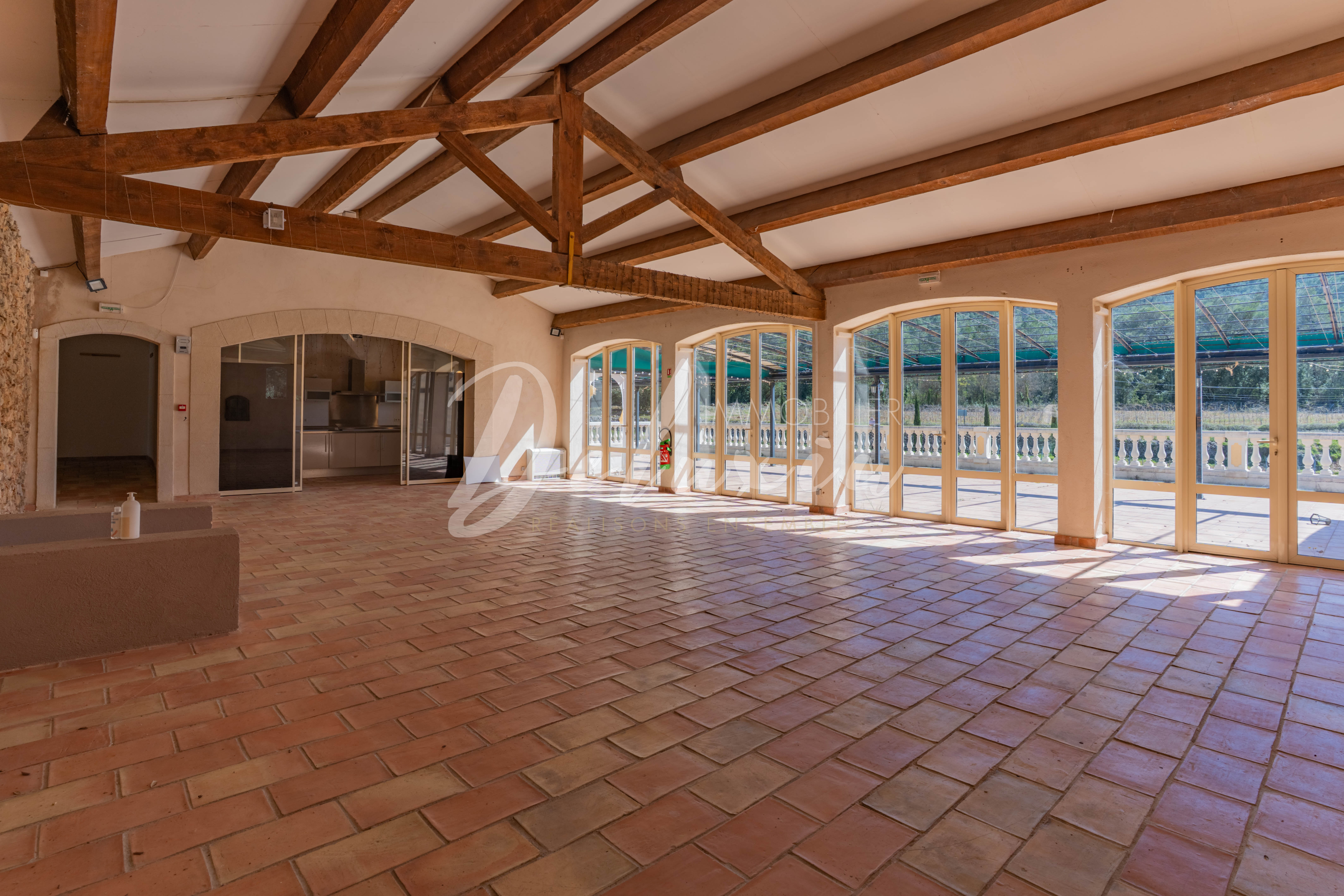 Salle de réception lumineuse avec charpente apparente – idéale pour événements et mariages en Provence